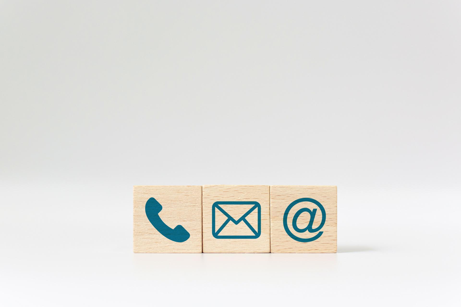 Wooden block cube symbol telephone, email, address. Website page contact us or e-mail marketing concept